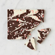 This is the premium peppermint bark handmade by the Long Grove Confectionery Company that combines dark and white chocolate with festive peppermint pieces. Founded in 1975 in the historic village of Long Grove, Illinois, the original family-owned chocolate shop and candy kitchen operated out of a nostalgic schoolhouse replica and prepared premium sweets that captured the small town&#8217;s quaint picturesque charm. The festive flavored bark blends decadent chocolate and is sprinkled with the cool crunch of crushed peppermint. The bark is broken into irregular pieces and shipped in a gift box. (10 oz.)
